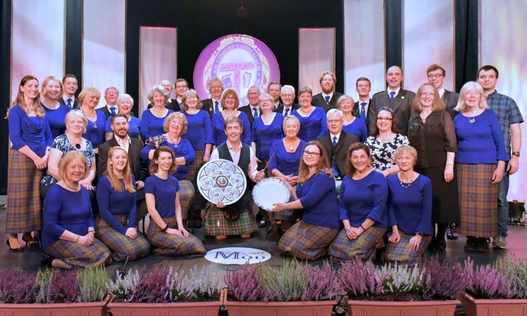 The Lothian Gaelic Choir holding the two main trophies they won at The Mòd gaelic festival.